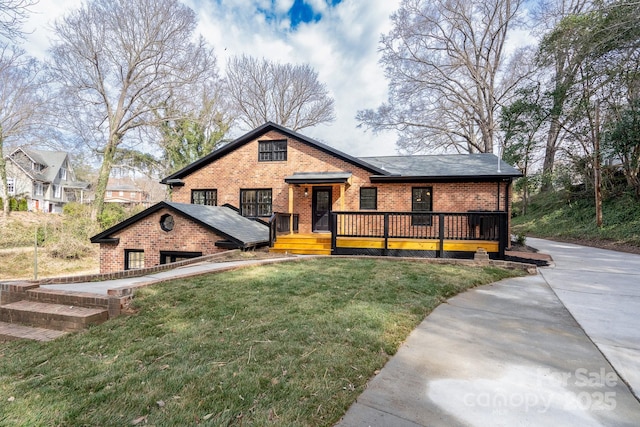 view of front of house featuring a wooden deck, a front yard, and brick siding