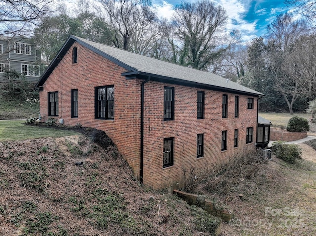 view of side of home featuring a lawn and brick siding