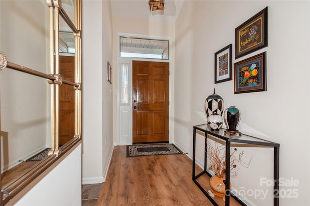 foyer featuring baseboards and wood finished floors