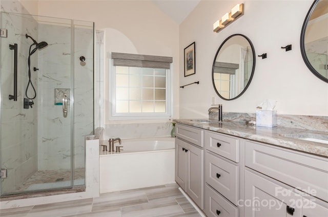 full bath with a garden tub, double vanity, a sink, and a marble finish shower