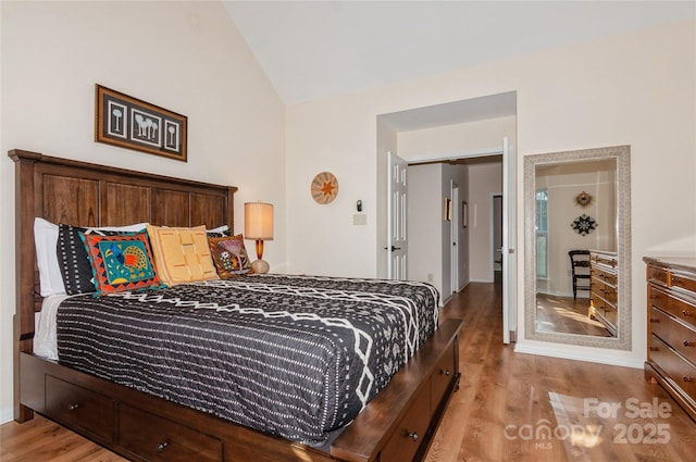 bedroom featuring vaulted ceiling and light wood-style flooring