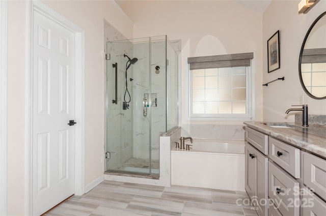 full bath with vanity, a garden tub, and a marble finish shower