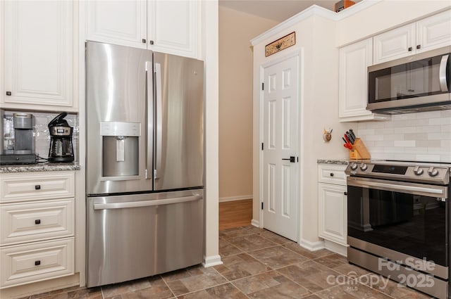 kitchen featuring stainless steel appliances, backsplash, white cabinets, and light stone countertops