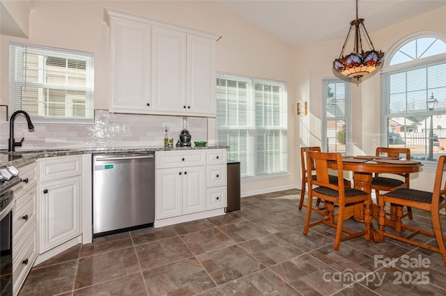 kitchen with white cabinets, lofted ceiling, appliances with stainless steel finishes, pendant lighting, and a sink