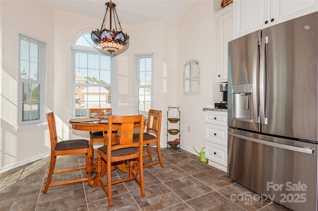 dining area with stone finish flooring and baseboards