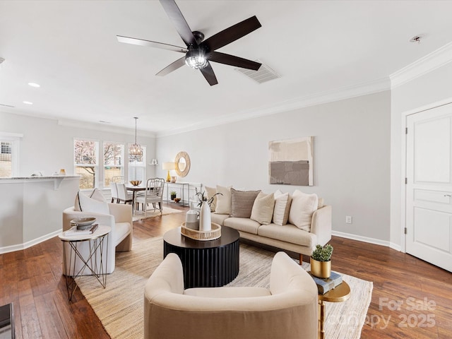 living room with hardwood / wood-style flooring, a ceiling fan, visible vents, baseboards, and crown molding