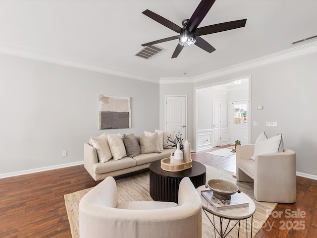 living area featuring wood finished floors, visible vents, and crown molding