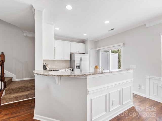 kitchen featuring visible vents, dark wood finished floors, stainless steel refrigerator with ice dispenser, and decorative backsplash