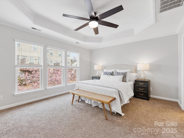 bedroom with carpet flooring, visible vents, baseboards, a raised ceiling, and crown molding