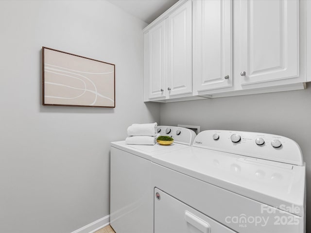 laundry room featuring cabinet space, baseboards, and washer and clothes dryer