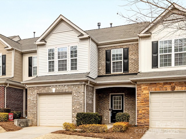 townhome / multi-family property with driveway, brick siding, roof with shingles, and an attached garage