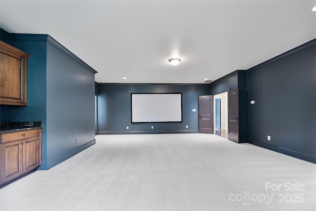 home theater room featuring light carpet and baseboards