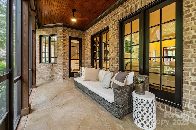 sunroom / solarium with a ceiling fan and wood ceiling