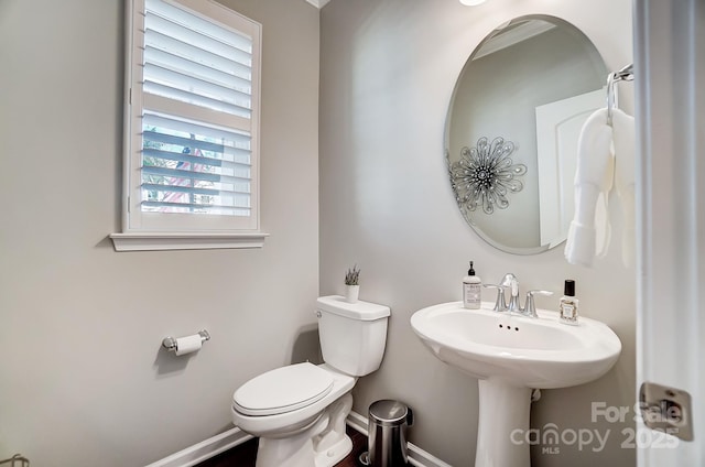 bathroom with baseboards and toilet