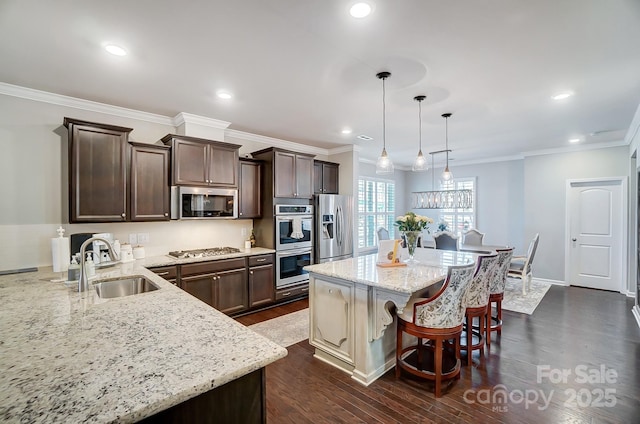 kitchen featuring a kitchen bar, a sink, appliances with stainless steel finishes, light stone countertops, and dark brown cabinets