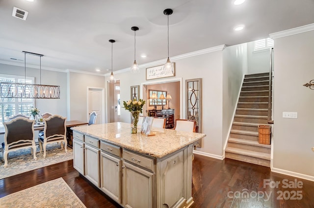 kitchen with dark wood finished floors, visible vents, and crown molding