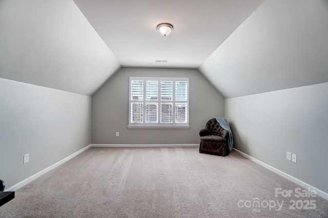 unfurnished room featuring visible vents, carpet, lofted ceiling, and baseboards