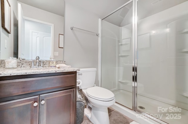 bathroom featuring vanity, toilet, a shower stall, and tile patterned flooring