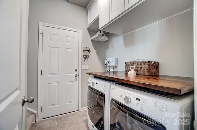 washroom featuring cabinet space, light tile patterned flooring, and washing machine and dryer