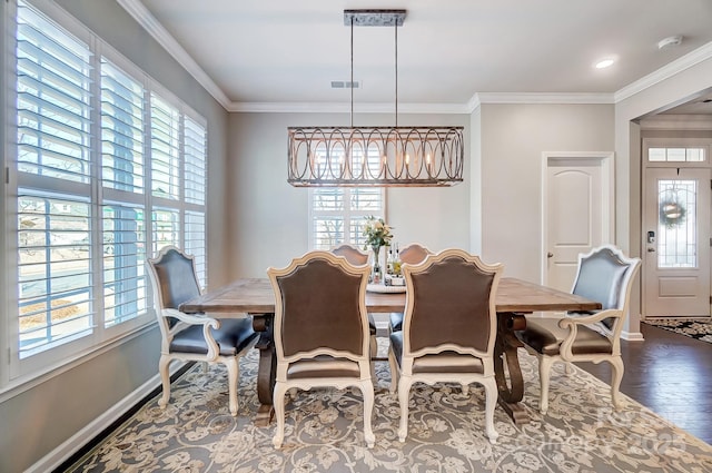 dining room with crown molding, visible vents, and a wealth of natural light