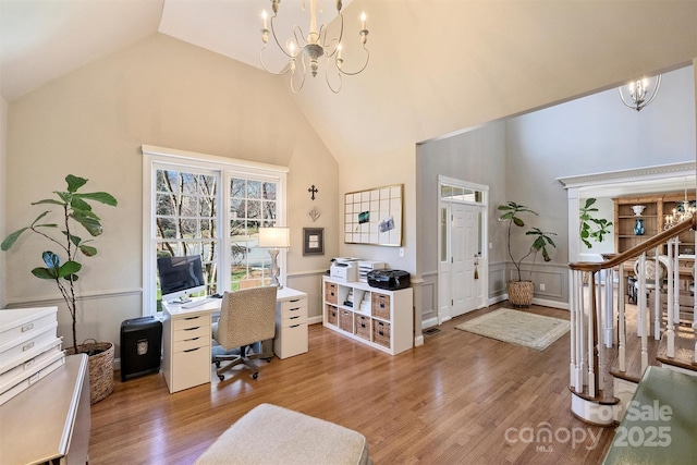 home office featuring a wainscoted wall, light wood-style flooring, and a notable chandelier