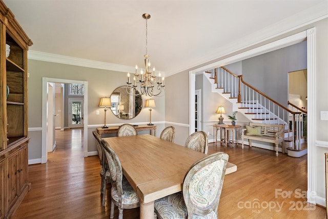 dining area with stairs, ornamental molding, and wood finished floors