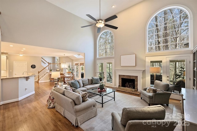 living area with a wealth of natural light, light wood-type flooring, and french doors