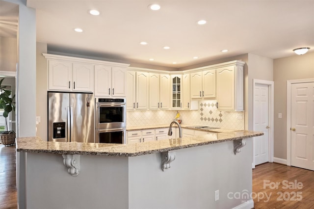 kitchen with stainless steel appliances, tasteful backsplash, and a kitchen bar