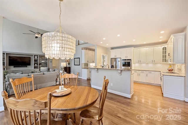 dining space with light wood-type flooring and recessed lighting