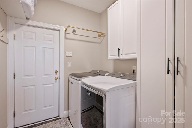 clothes washing area with cabinet space and washing machine and clothes dryer