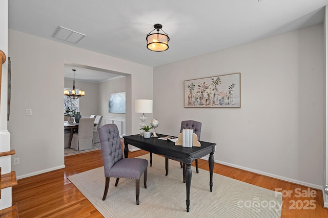 office area featuring a notable chandelier, visible vents, baseboards, and wood finished floors