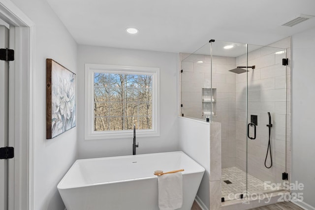 bathroom featuring a soaking tub, recessed lighting, visible vents, and a stall shower