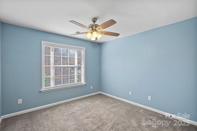 carpeted empty room with ceiling fan and baseboards