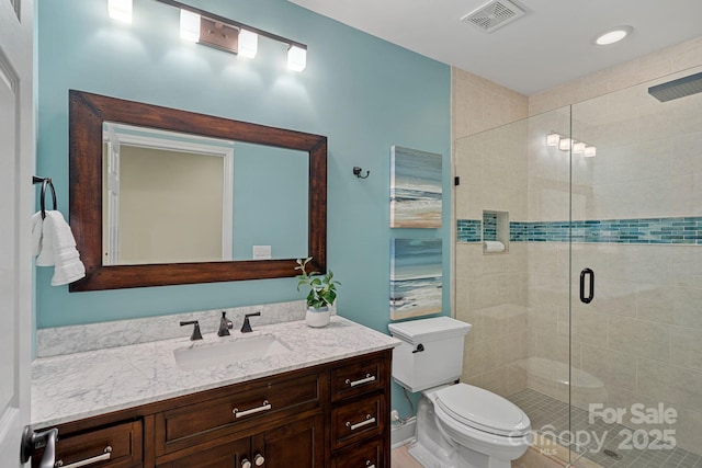 full bath with a stall shower, visible vents, vanity, and toilet