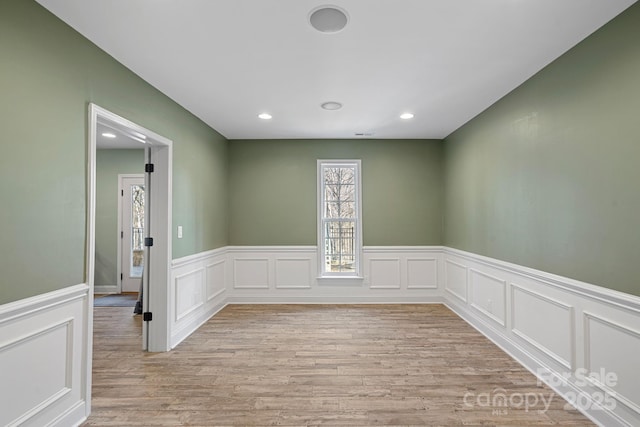 empty room with a wainscoted wall, light wood-style flooring, and recessed lighting