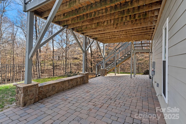 view of patio featuring stairway and fence