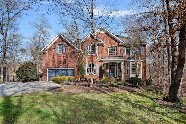 view of front of house with a front yard, brick siding, driveway, and an attached garage