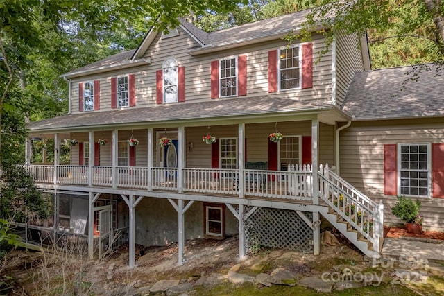 view of front of property featuring a porch, stairway, and a shingled roof