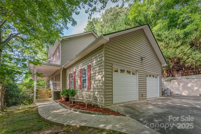 view of home's exterior featuring a garage, covered porch, fence, and driveway