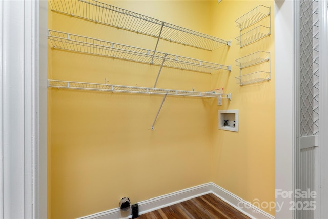 clothes washing area featuring washer hookup, laundry area, baseboards, and wood finished floors