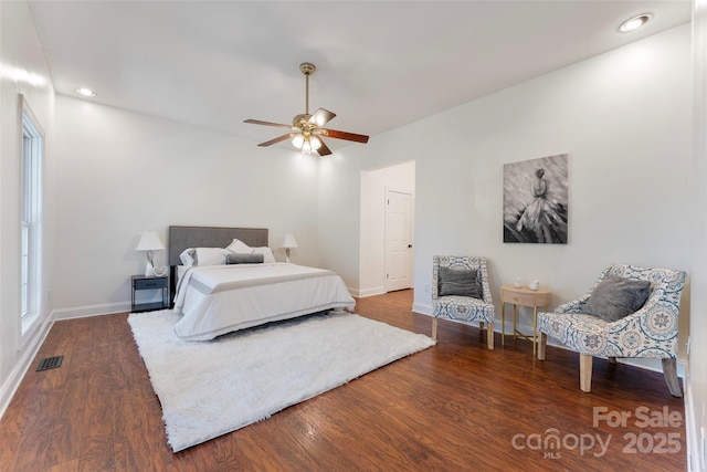 bedroom featuring dark wood-style floors, baseboards, visible vents, and a ceiling fan