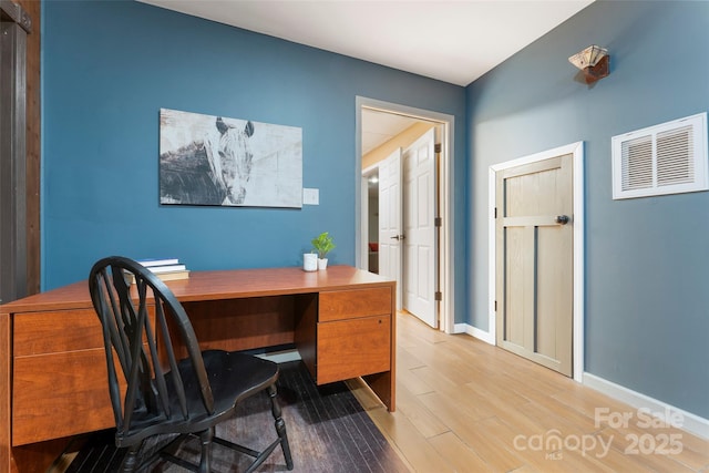 office with baseboards, visible vents, and light wood finished floors