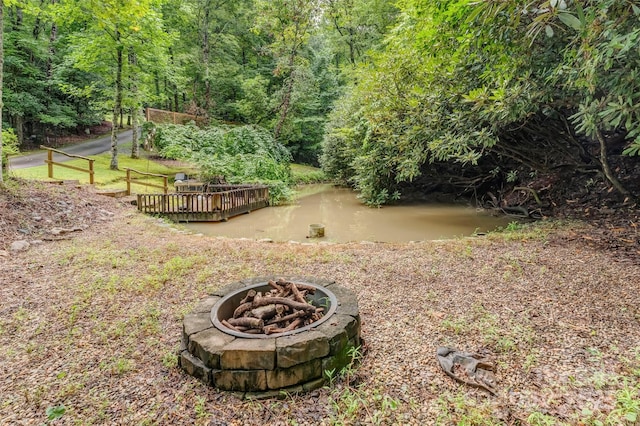 view of yard featuring an outdoor fire pit and a water view