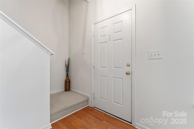 foyer entrance featuring baseboards and light wood-style floors