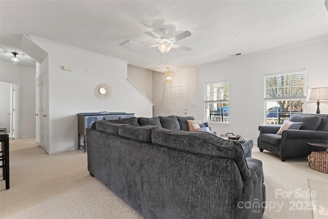 living room featuring visible vents, light colored carpet, ceiling fan, and a textured ceiling