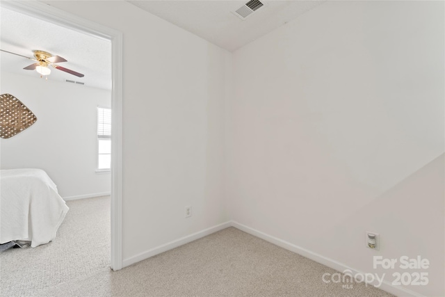 interior space with visible vents, baseboards, and light colored carpet