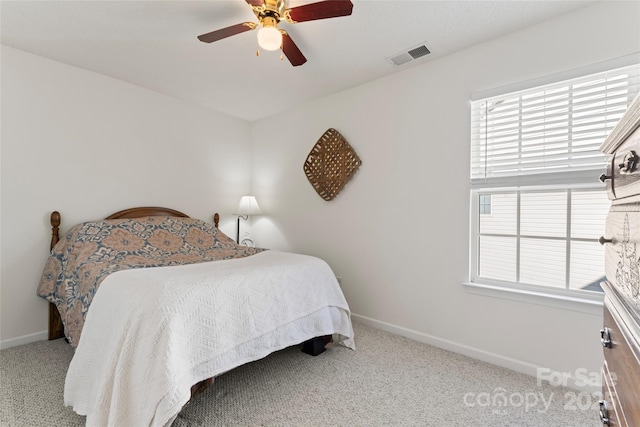 carpeted bedroom with a ceiling fan, baseboards, and visible vents