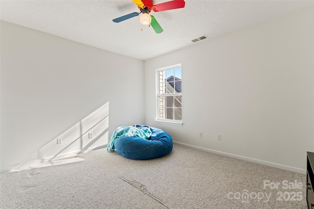 interior space with visible vents, baseboards, ceiling fan, carpet flooring, and a textured ceiling