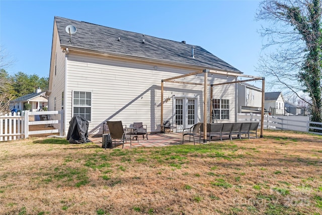 rear view of property featuring a fenced backyard, a pergola, french doors, a patio area, and a lawn