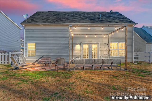 rear view of property with fence, a yard, a shingled roof, a patio area, and an outdoor hangout area